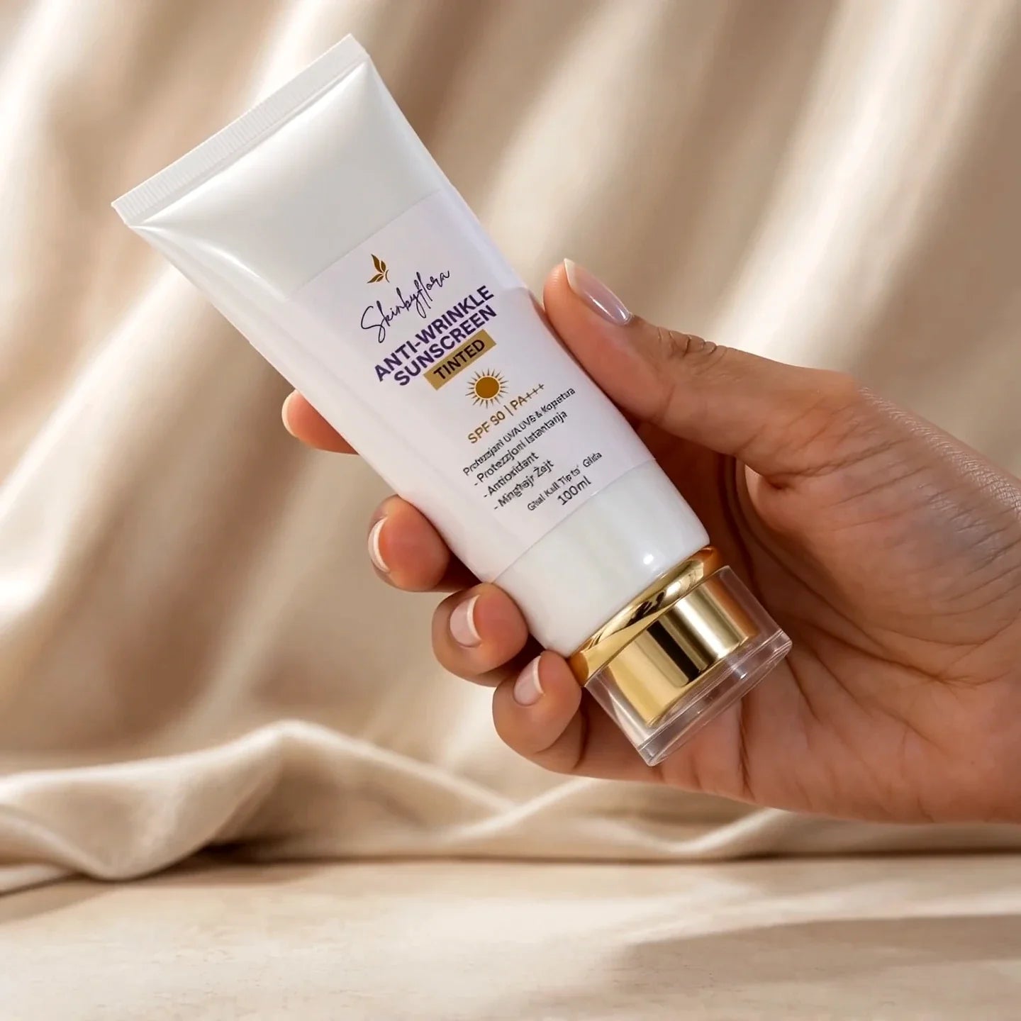 Skin by Flora Anti-Wrinkle Tinted Sunscreen SPF 90 held in hand